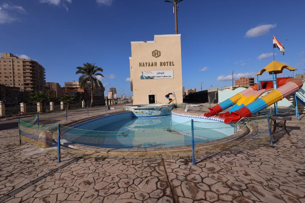 Damanhûrفندق حياة دمنهور - Hayat Hotel Damnhour的大楼前带滑梯的游泳池