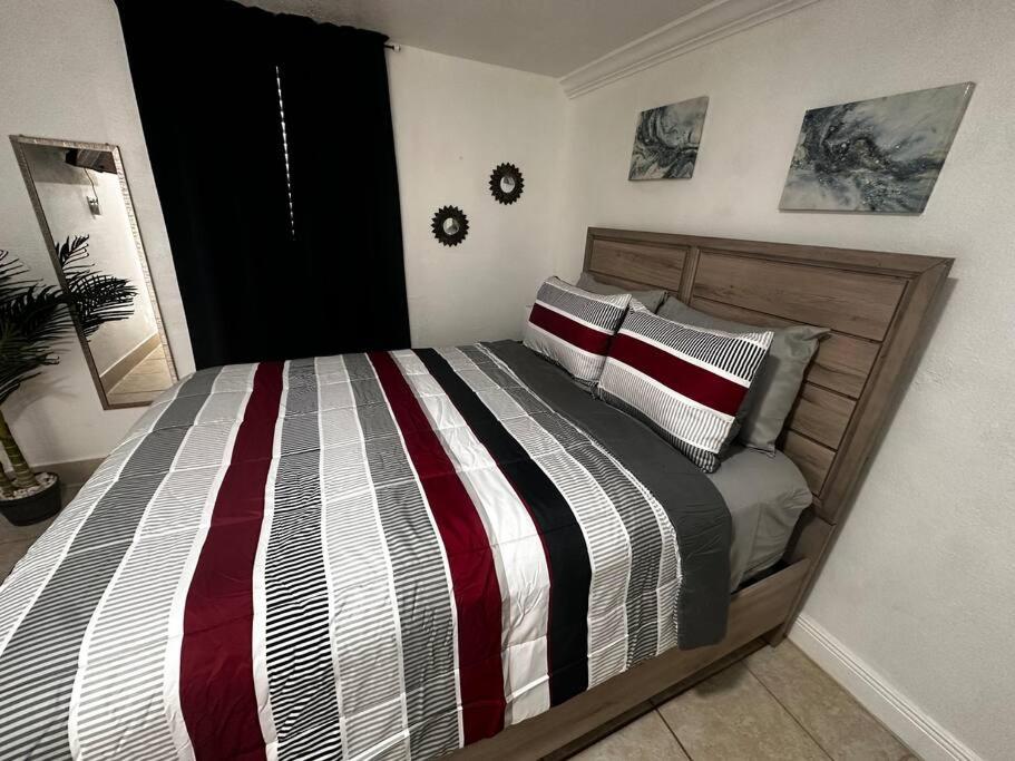 迈阿密花园Miami Breeze Studio的一间卧室配有带条纹被子的床