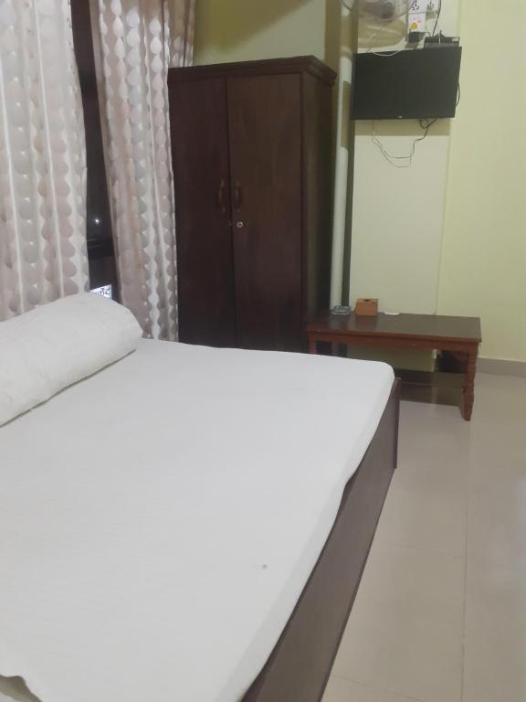 巴拉特布尔Om siddhababa Restaurant and Lodge的卧室配有白色的床和木制橱柜。