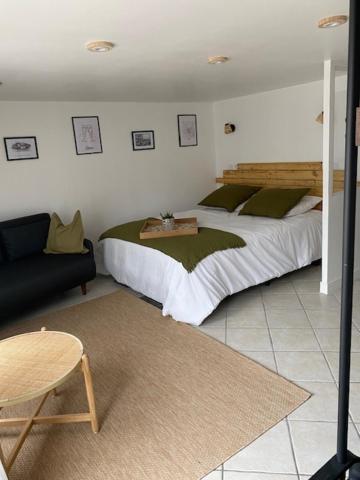 蒂恩奎克斯appart studio complet RDC de maison avec extérieur的一间卧室配有一张大床和一张沙发
