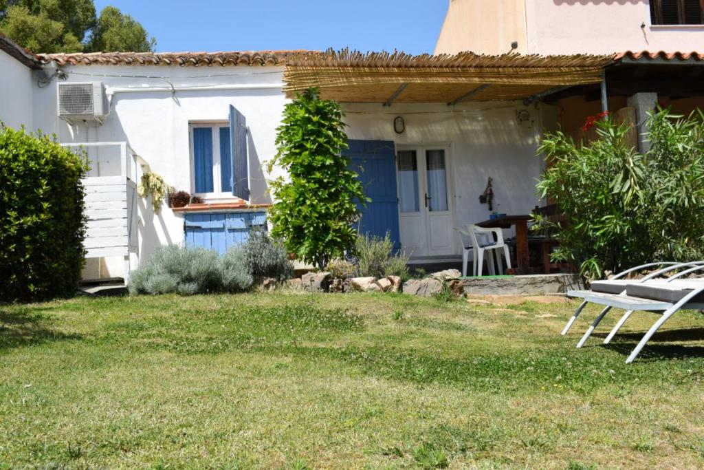 奥尔比亚Sa Domitta di Suiles的一间白色的小房子,设有蓝色的门