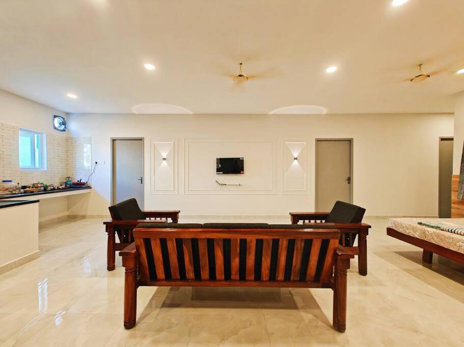 钦奈HOMESTAY - AC 5 BHK NEAR AlRPORT的客厅设有长凳和墙上的电视