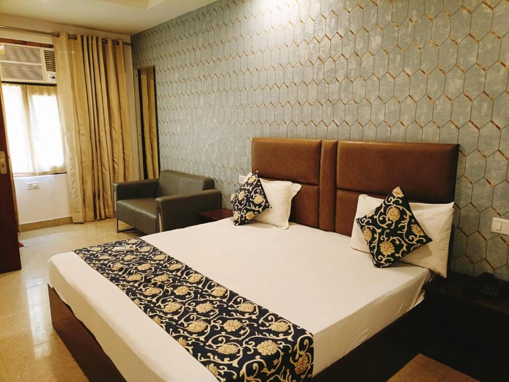 新德里Hotel Ambience Palace Near IGI Airport Delhi的一间卧室配有一张床和一把椅子