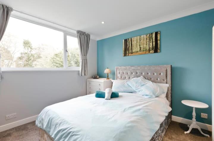 Horsell30 Woodlands的卧室配有白色床和蓝色墙壁
