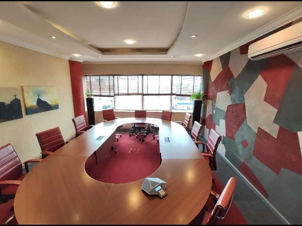 内罗毕Park Place Business Center的大型会议室,配有大型木桌和椅子
