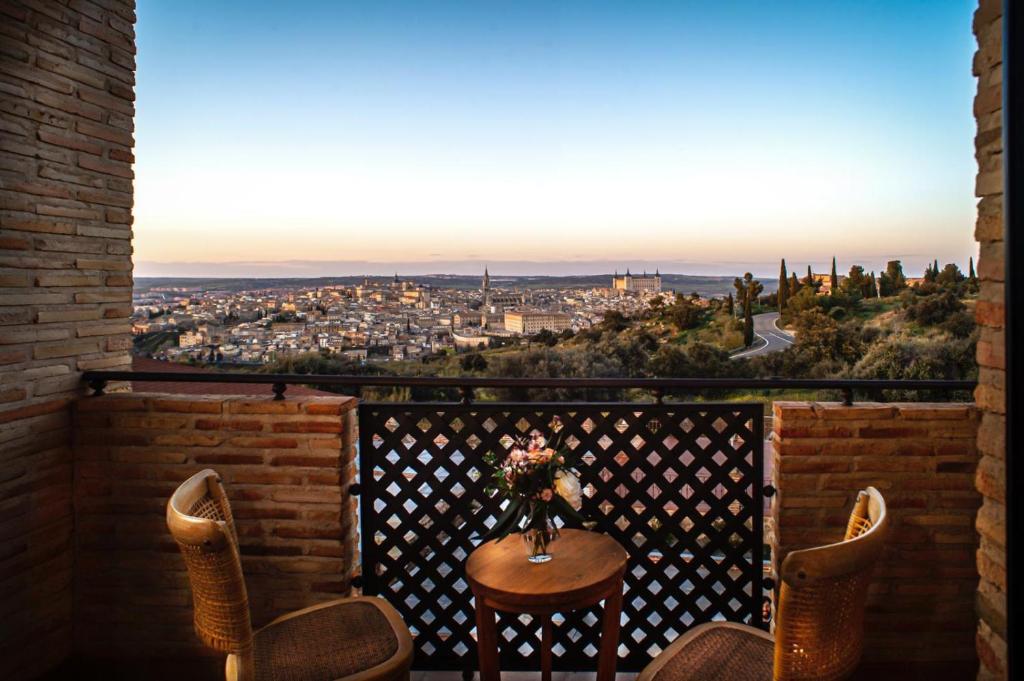 托莱多Hotel Cigarral Santa María的美景阳台配有桌椅
