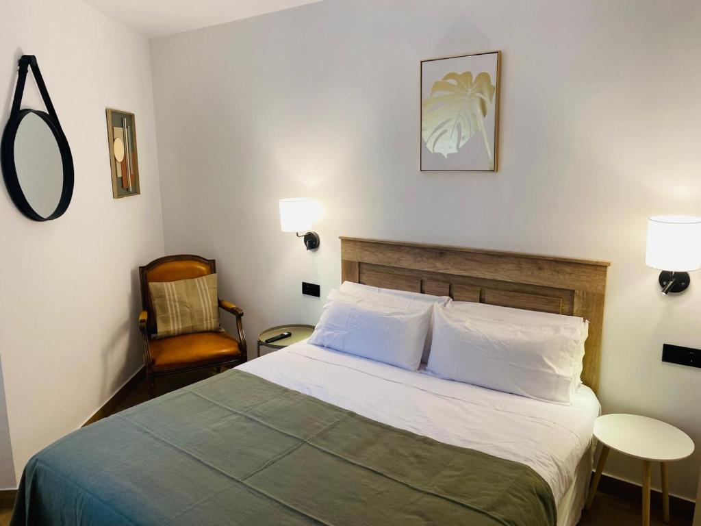 梅里达El Parador del César的一间卧室配有一张大床和一把椅子