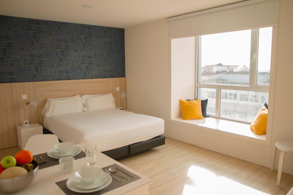 波尔图room Select Porto Suites的酒店客房,配有床和一张带水果的桌子