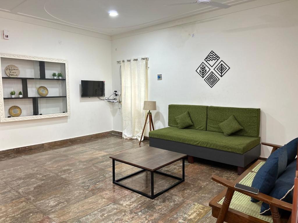 钦奈SAIBALA HOMESTAY - AC 3 BHK NEAR AlRPORT的客厅配有绿色沙发和桌子