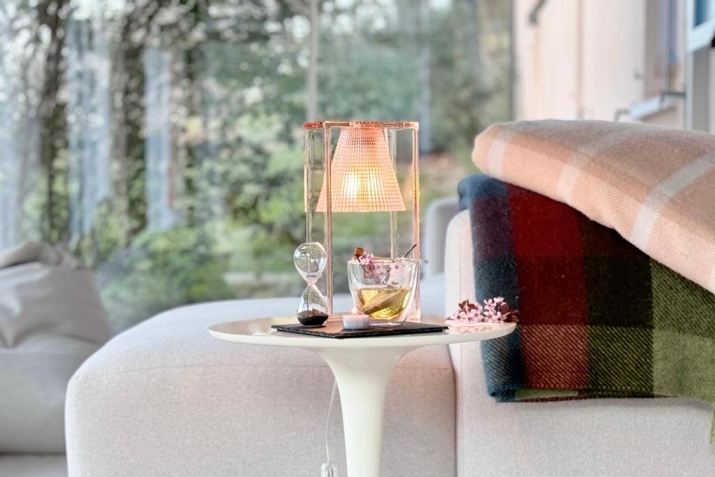 福松布罗内Agriturismo "Le Cannelle" spa & day wellness的一张桌子,上面有两杯眼镜和沙发上的一盏灯