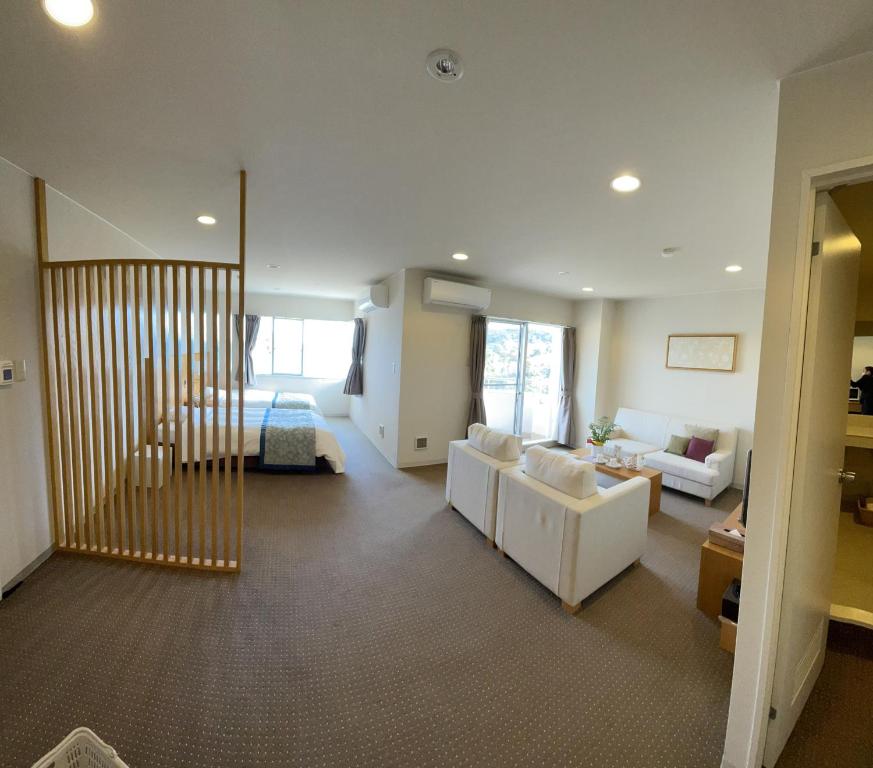 鸟羽鸟羽维斯特里安生活俱乐部酒店的客厅配有沙发和1张床