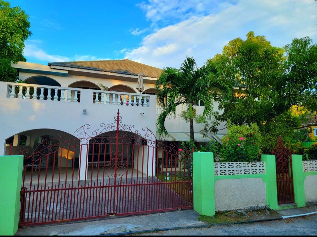Oracabessa绿宫牙买加酒店的一座有红色门和栅栏的房子