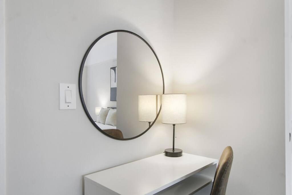芝加哥3BR Vibrant Apartment in Hyde Park - Bstone 5310-1的桌子上方墙上的镜子,带灯