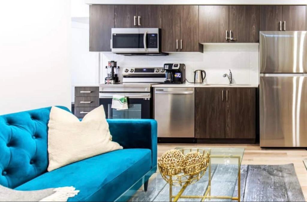 尼亚加拉瀑布New Luxury Suite 6Mins To Falls, Free Parking的一间带蓝色沙发的客厅和一间厨房