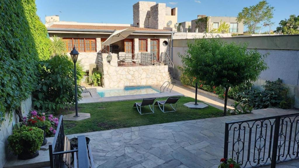 门多萨Hotel Boutique Casa & Cava的庭院内带游泳池和两把椅子的房子