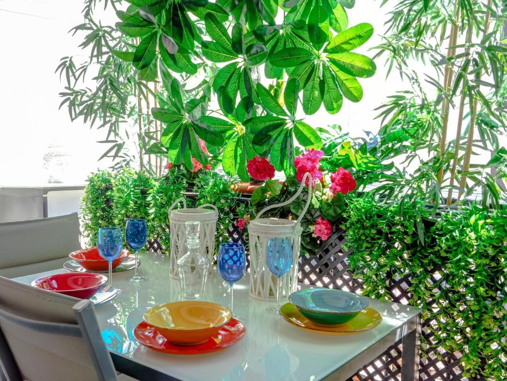 锡切斯Flamingo Apartment by Hello Homes Sitges的植物上带板子和花瓶的桌子