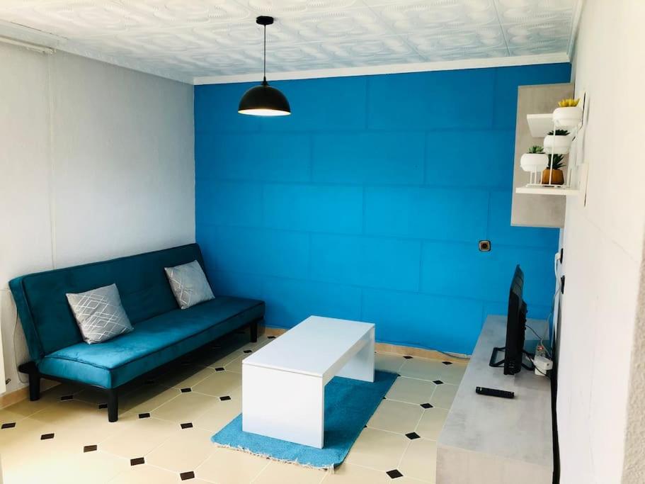 普埃托利亚诺Acogedor apartamento muy cerca del centro的带沙发和蓝色墙壁的客厅
