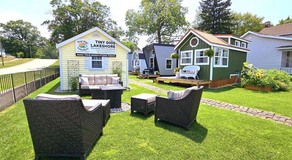 马斯基根Tiny Digs Lakeshore - Tiny House Lodging的一个带椅子的院子和一个小房子