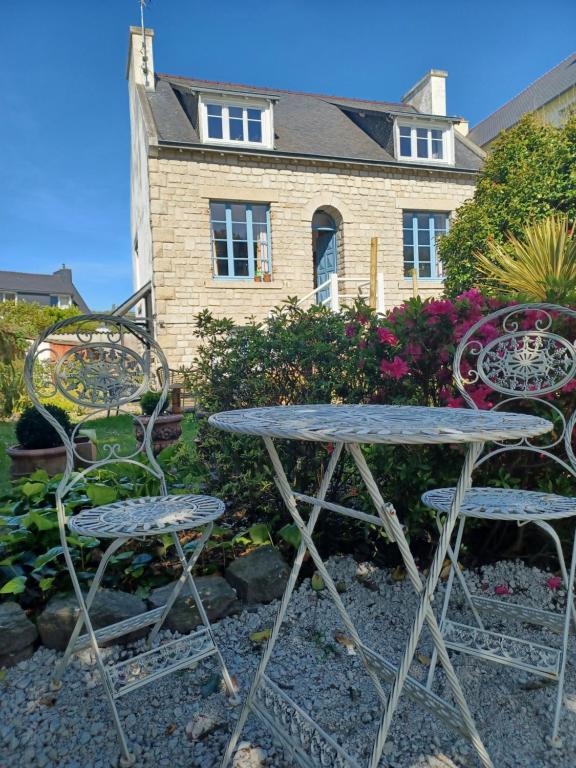 坎佩尔Le Banellou的桌子和两把椅子位于房子前面