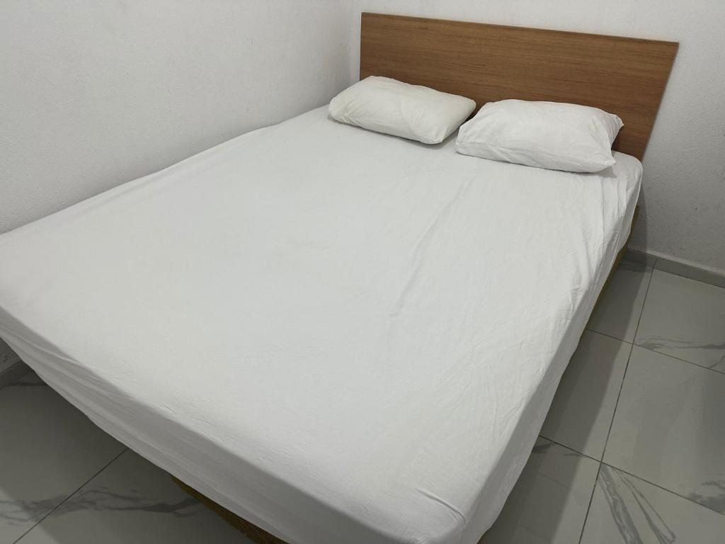 恰纳卡莱Nr1 Pansiyon的一张带白色床单的床和两个枕头