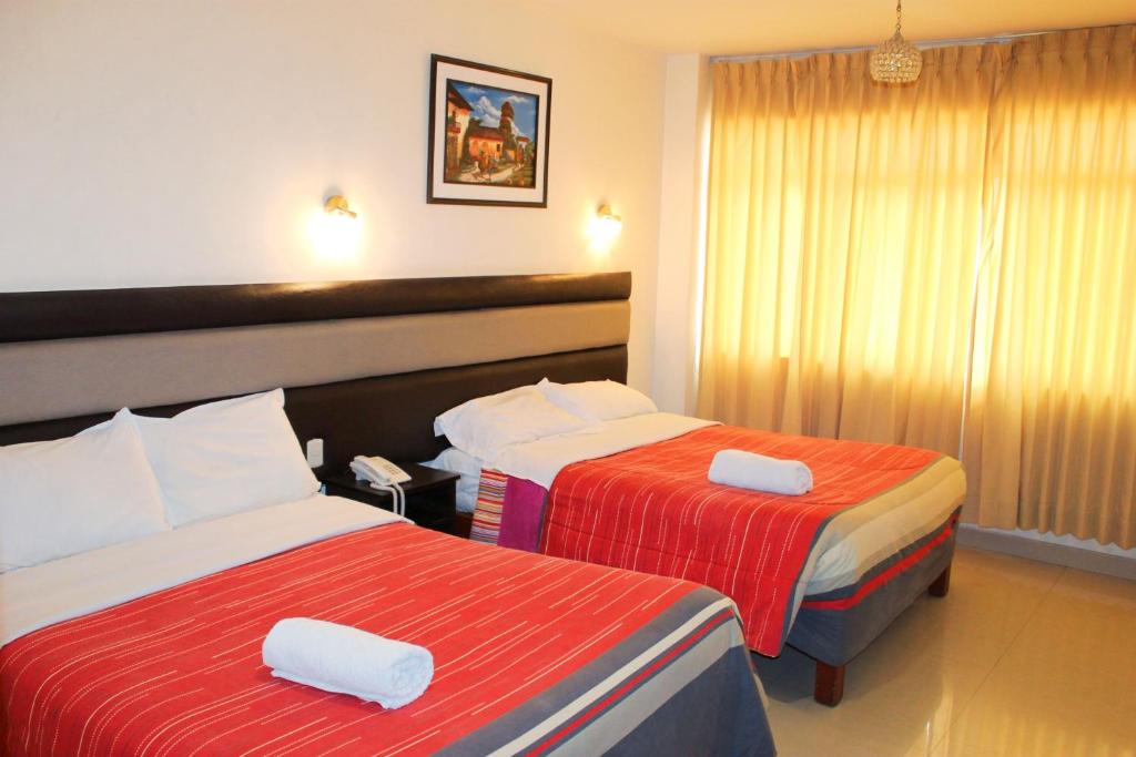 塔克纳Hotel Reggia的酒店客房,配有两张带毛巾的床