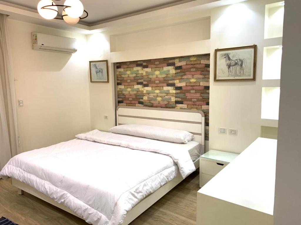 Sheikh Zayedشقه فندقية للإيجار بالشيخ زايد的一间卧室设有两张床和砖墙