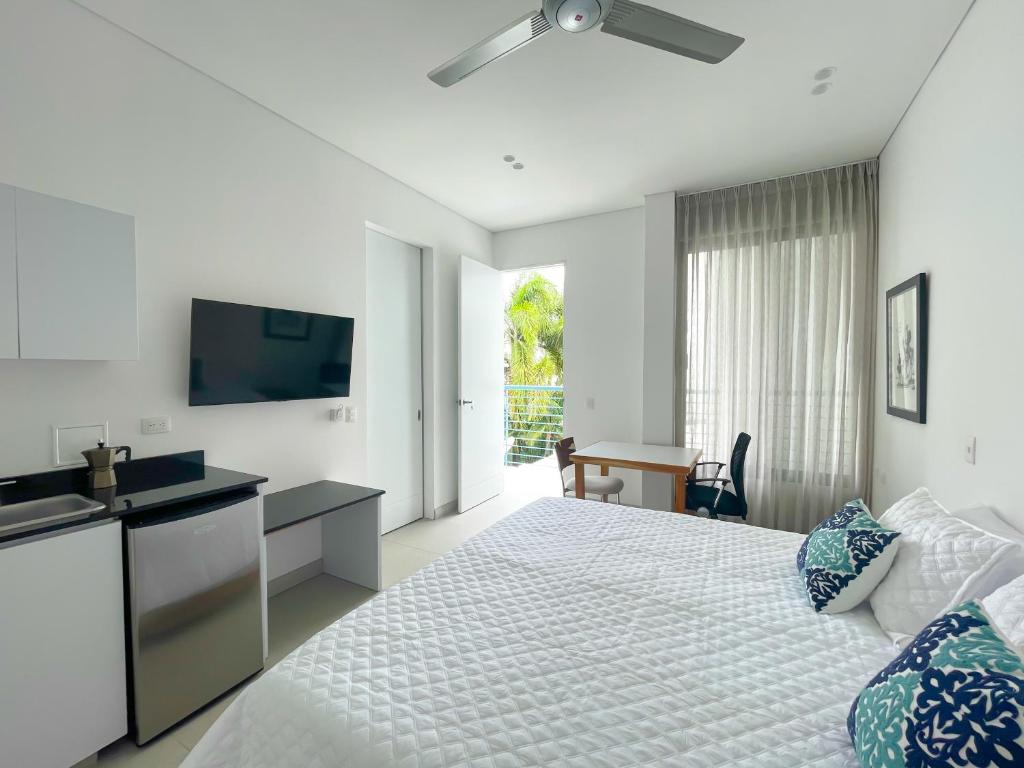 蒙特里亚Apartaestudio Brumilo 2的一间白色卧室,配有床和电视