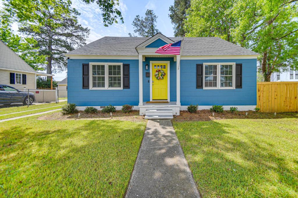 伊丽莎白城Elizabeth City Abode with Fenced Yard, Near Downtown的蓝色的房子,有黄色的门和美洲国旗