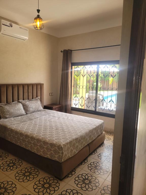 马拉喀什Villa Ama的一间卧室设有一张大床和一个窗户。