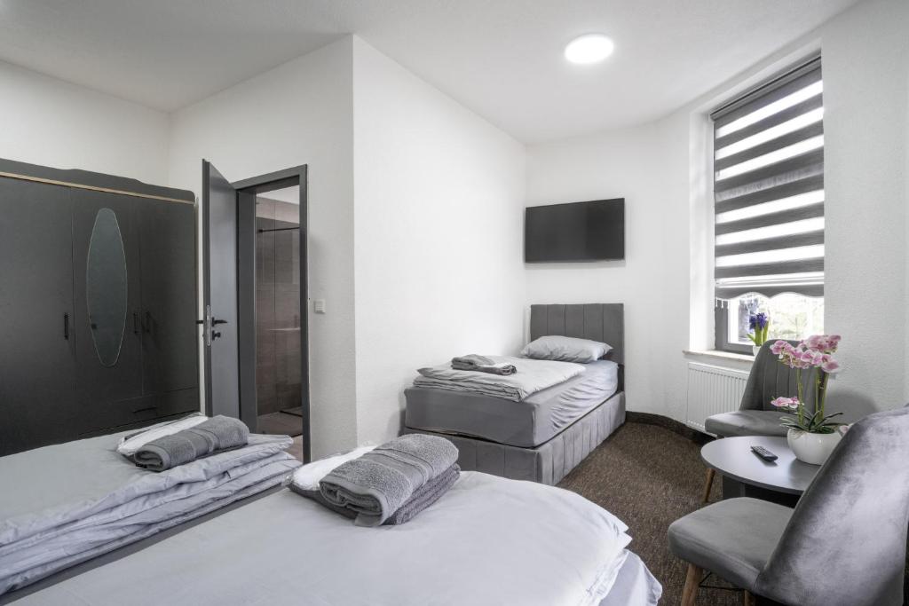 杜伊斯堡Duisburger Hostel的白色客房 - 带两张床和椅子
