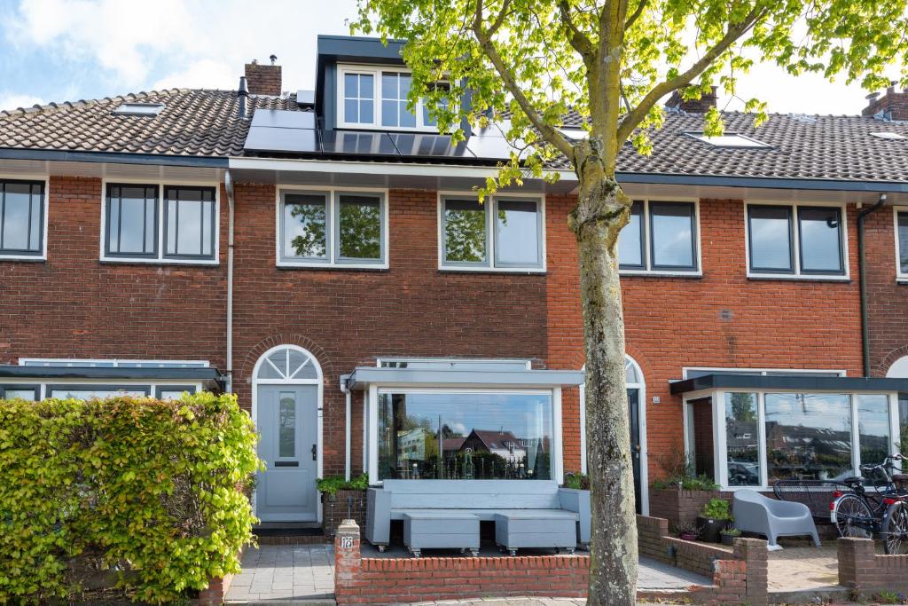 希佛萨姆Beautiful house n.Amsterdam, suitable for families的砖屋,有白色的窗户和树