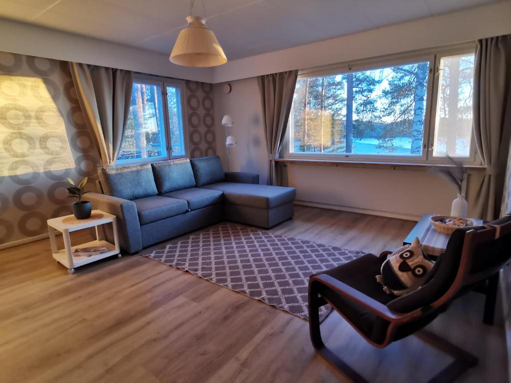 VuoriniemiVuori Camp by Saimaa的客厅设有蓝色的沙发和2扇窗户。