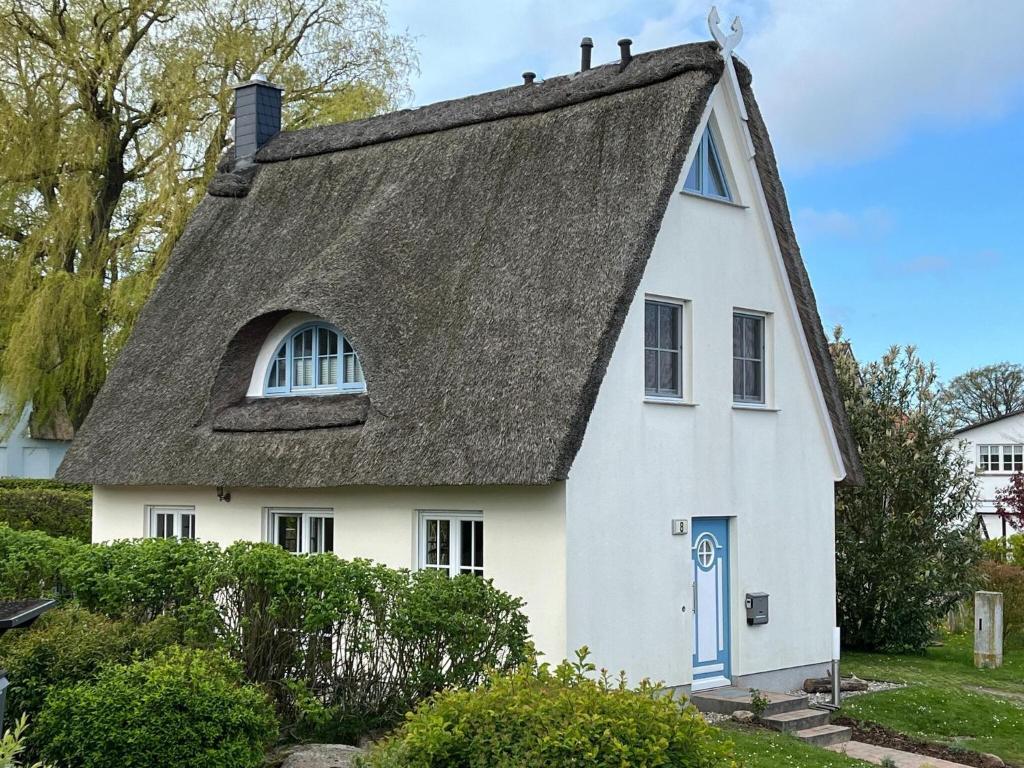 沃伦伯格Reetdachhaus mit eigenem Strandkorb in Wohlenberg an der Ostsee的白色的茅草屋顶房屋