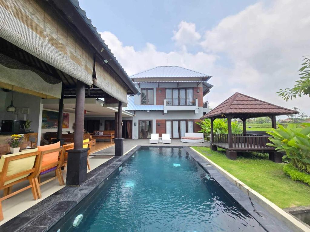 PenginyahanBelvilla 93799 Kasuari Villa Three Bedroom At Taro Village Ubud的一座房子后院的游泳池