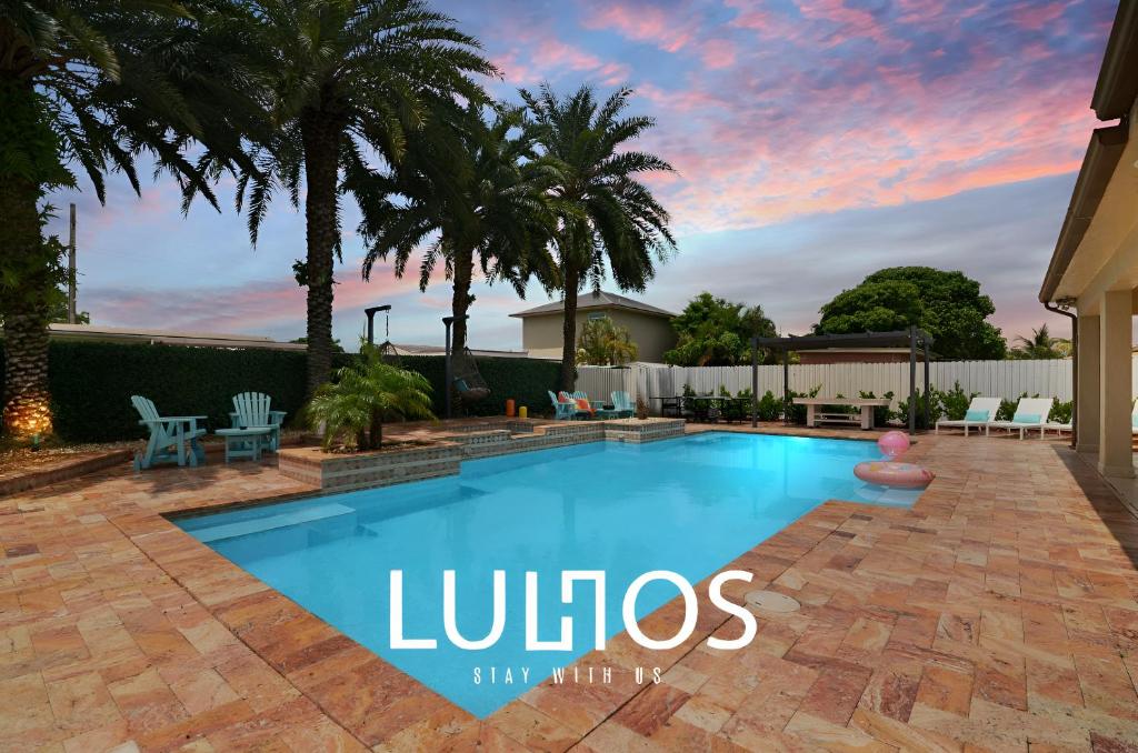 迈阿密花园Oasis with Pool Spa Games 5BR L21的棕榈树庭院内的游泳池