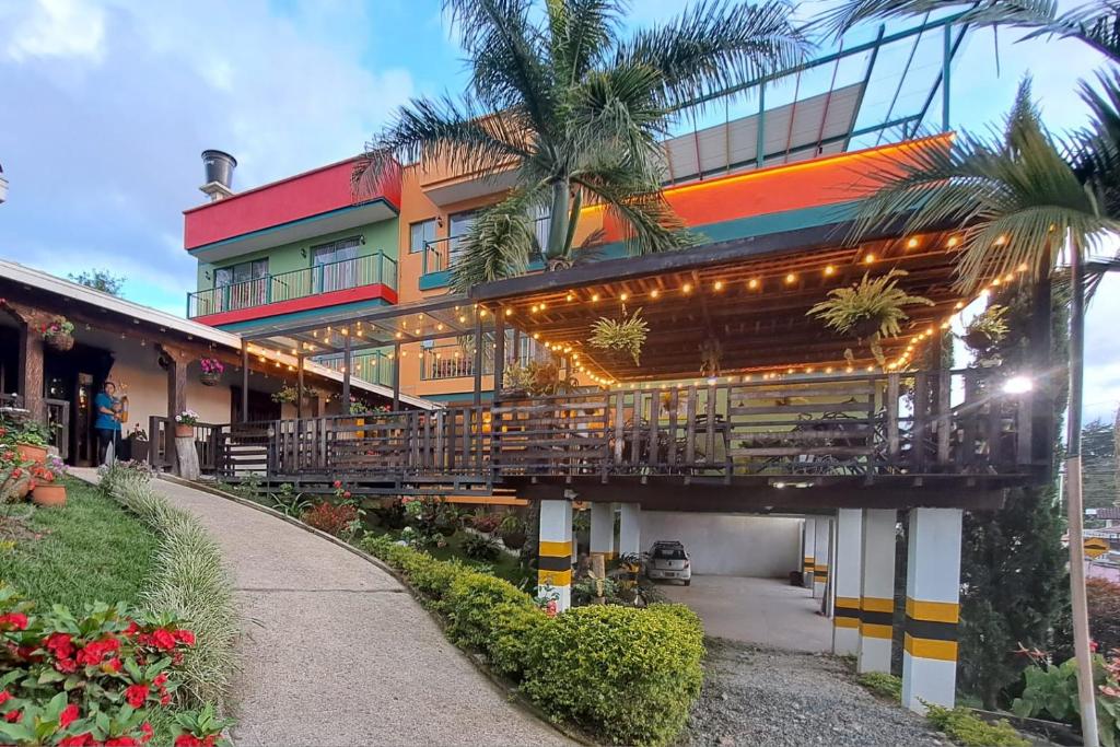 瓜塔佩Guatapé Country House Hotel的带阳台和棕榈树的建筑