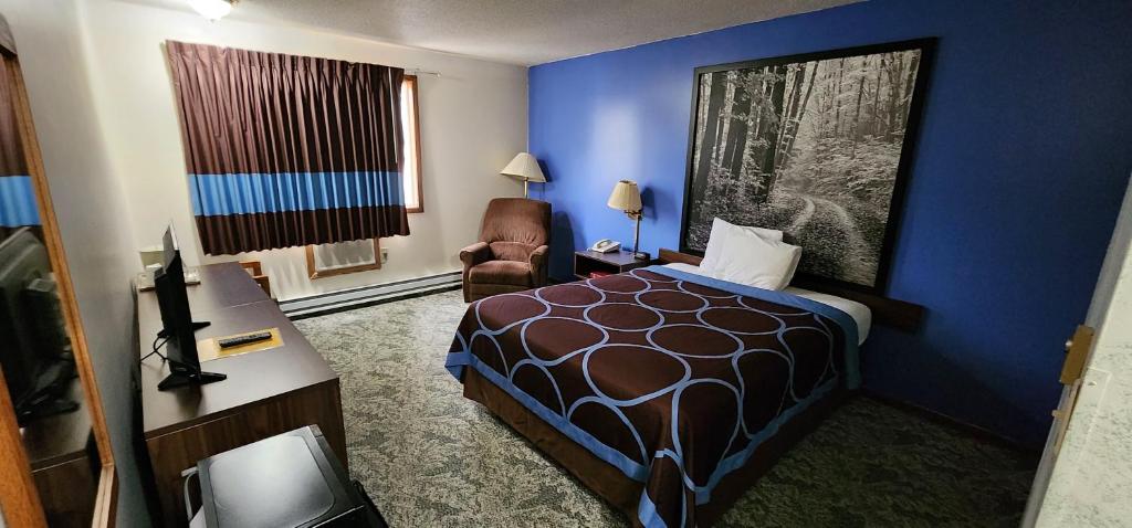 艾恩芒廷Hotel Iron Mountain Inn & Suites - Stay Express Collection的配有一张床和一把椅子的酒店客房
