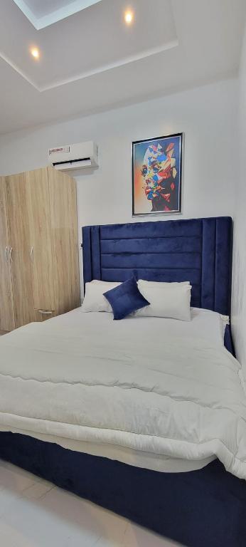 AwoyayaBlue Luxury的卧室内的一张带蓝色床头板的大床