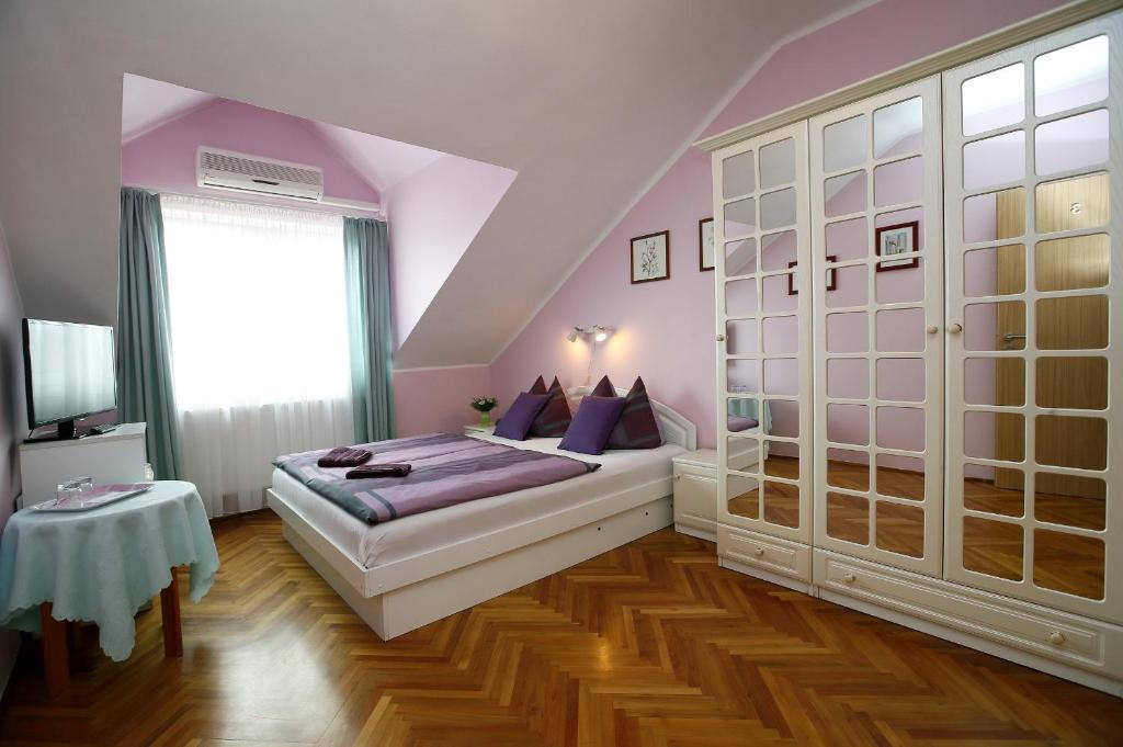 埃格尔赛斯温德加兹酒店的一间卧室配有一张紫色墙壁和木地板的床。