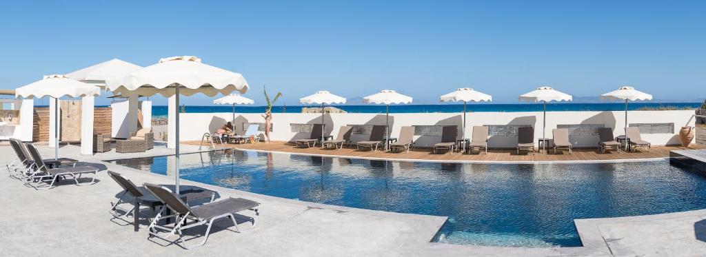帕拉代西翁Viva Tourismo Resort (naturist club)的一个带躺椅和遮阳伞的游泳池