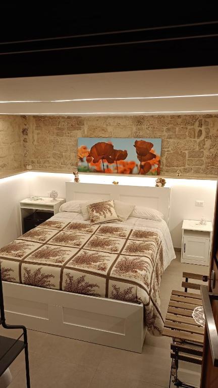 巴里IL CORTILETTO的一间卧室配有一张大床和两张桌子