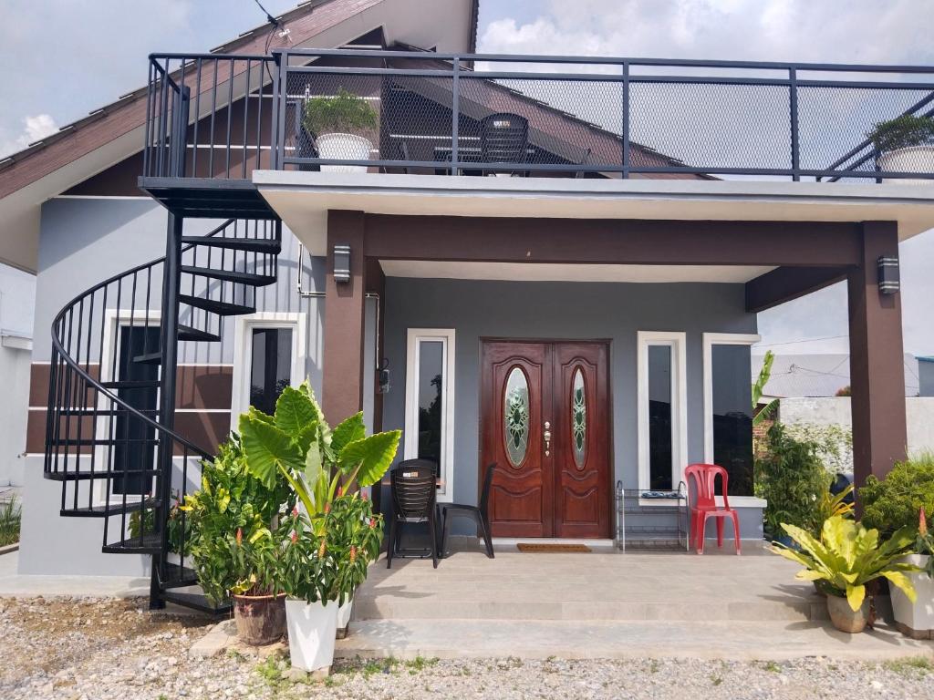珍南海滩Villa Adeeva Homestay Langkawi的带阳台和红色门的房子