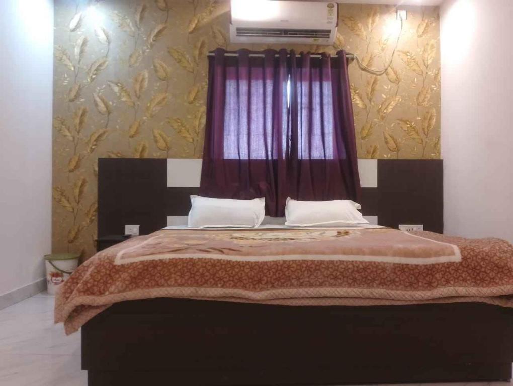 HazārībāgHotel Alakhraj Palace的一间卧室配有一张带红色窗帘的大床
