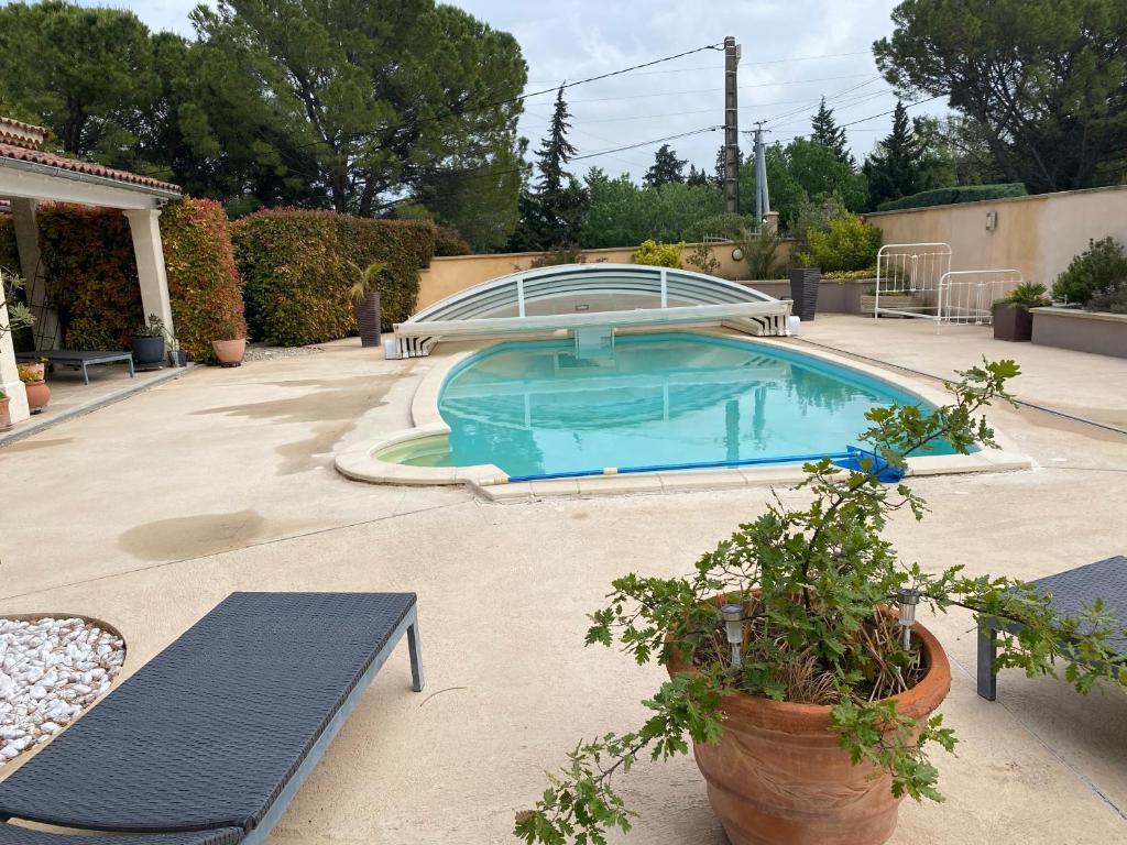 Châteauneuf-de-GadagneBeau Ciel的一个带两个长椅的庭院内的游泳池