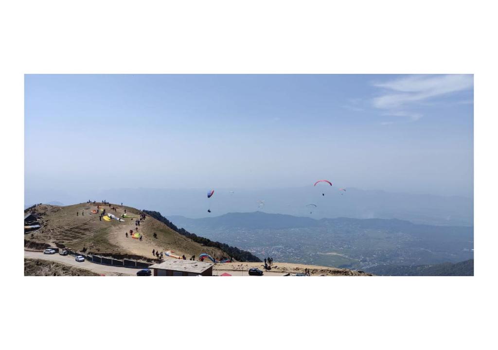 Baijnāththevillagercamp的天空中风筝的山丘景色