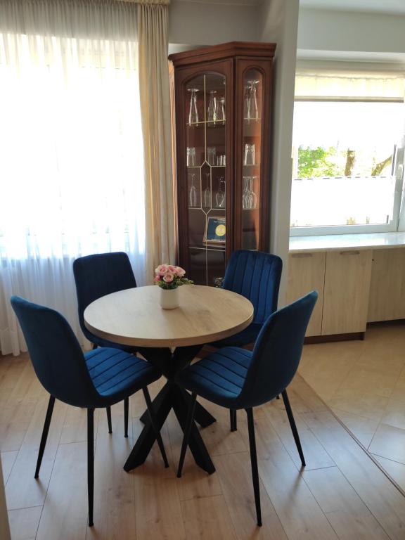 奥尔什丁Apartament Familijny的一间带桌子和蓝色椅子的用餐室