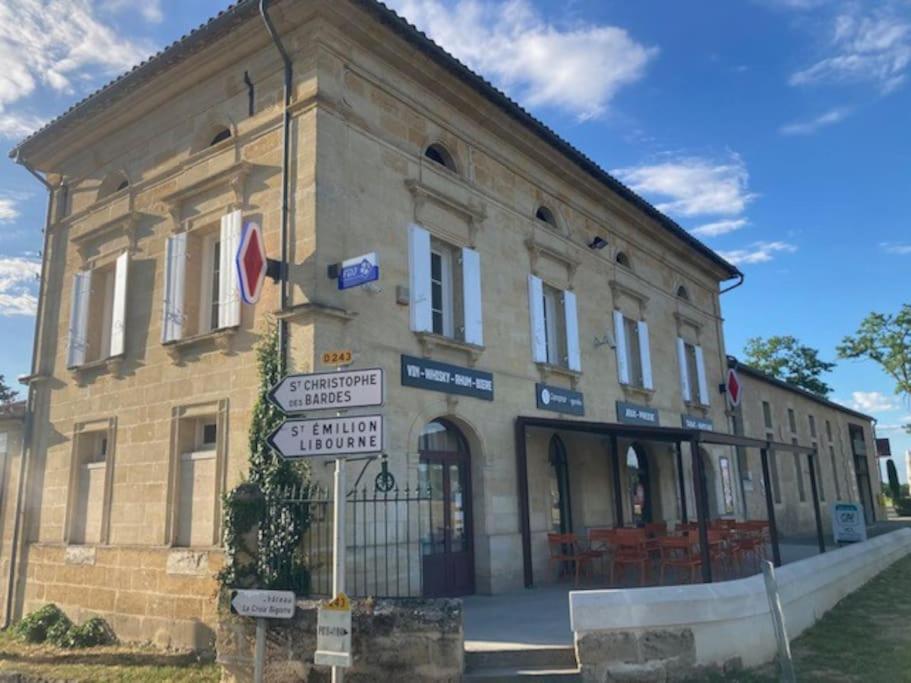 Saint-Genès-de-CastillonL'Appartement du Comptoir的前面有路标的砖砌建筑