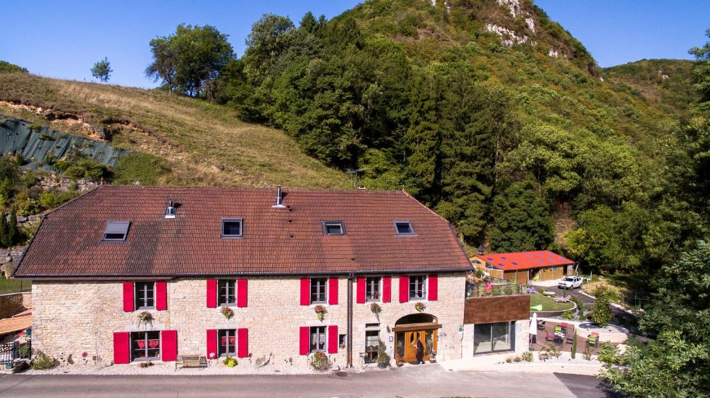 PretinDomaine et chambres d'Hôtes des Fées的一座带红色百叶窗和山的古老房子