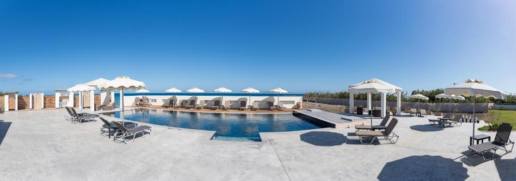 帕拉代西翁Viva Tourismo Resort (naturist club)的庭院内一个带椅子和遮阳伞的游泳池