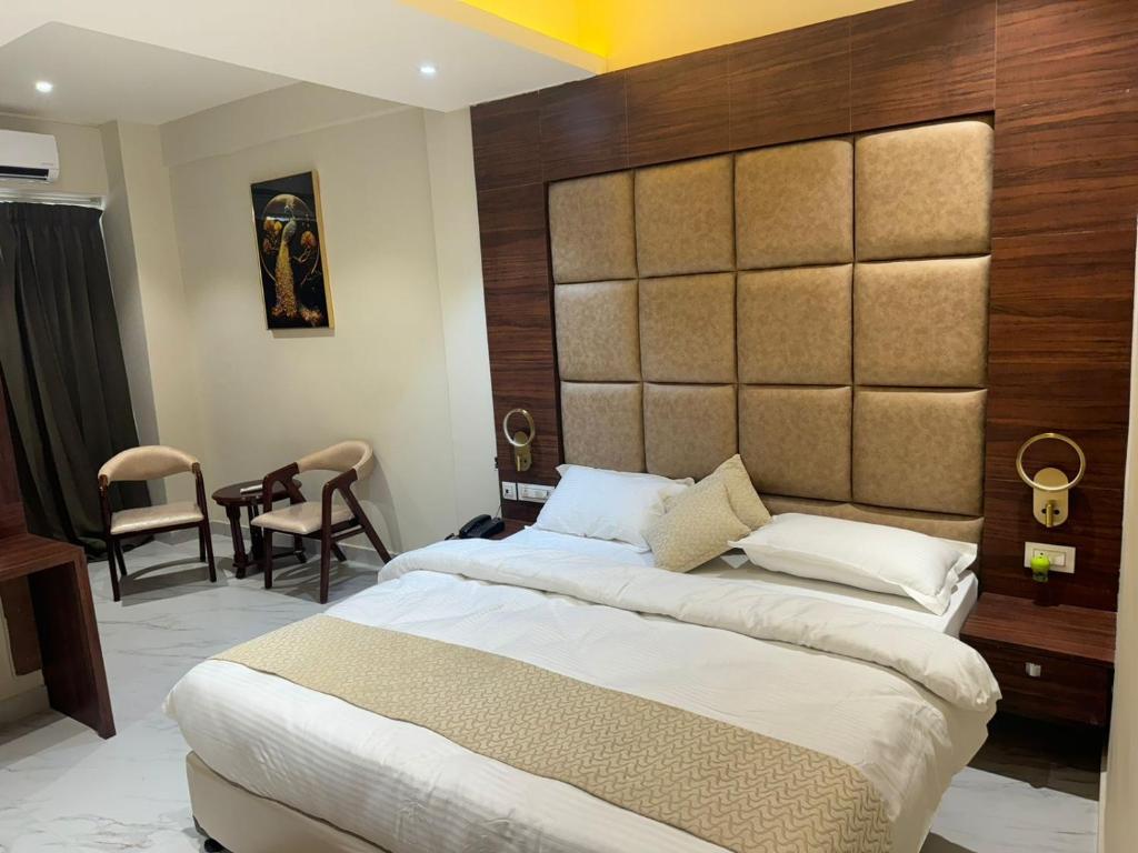 BettiahHotel Asha & Banquet的一间卧室配有一张大床和大床头板